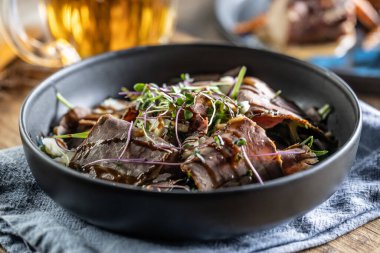 Biftek salatası, şifalı otlar ve balzamik sosla restoran masasında kase şeklinde..