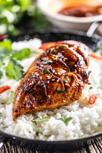 Tavada ızgara tavuk göğsü, yasemin pilavı ve biberle servis ediliyor..