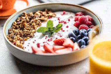 Bir kase dolusu böğürtlen, yoğurt ve mısır gevreği. Sağlıklı kahvaltı kavramı.