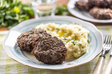 Kıymalı pirzola ve üzerine tereyağı sürülmüş patates püresi. Geleneksel Slovak köfteleri - Patates püresi ile büyüleyici.