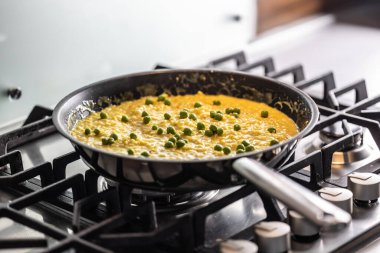 Gaz ocağında tavada pişmiş bezelyeli Saffron risotto..