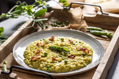 İtalyan safranlı risotto bezelye ve pastırma tabakta yaratıcı bir şekilde servis edilir..