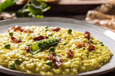 İtalyan safranlı risotto bezelye ve pastırma tabakta yaratıcı bir şekilde servis edilir..