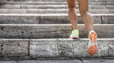 Şehir merdivenlerinde koşan atlet bacakları. Kadın fitness koşu sağlık konsepti.