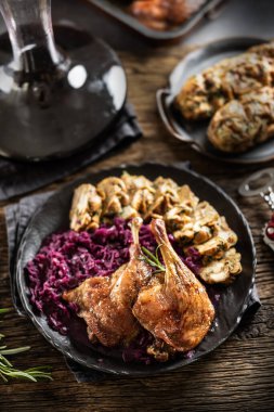 Kızartma kısmı ördek bacak kırmızı lahana ev yapımı köfte arka plaka ve kırmızı şarap.