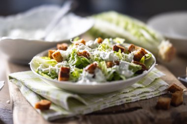 Romaine marulu, kızarmış ekmek, tzatziki sosu ve parmesan peynirinden yapılmış sağlıklı Sezar salatası. İtalya kökenli geleneksel Akdeniz Sezar salatası.