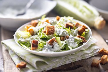 Romaine marulu, kızarmış ekmek, tzatziki sosu ve parmesan peynirinden yapılmış sağlıklı Sezar salatası. İtalya kökenli geleneksel Akdeniz Sezar salatası.