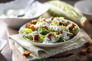 Romaine marulu, kızarmış ekmek, tzatziki sosu ve parmesan peynirinden yapılmış sağlıklı Sezar salatası. İtalya kökenli geleneksel Akdeniz Sezar salatası.