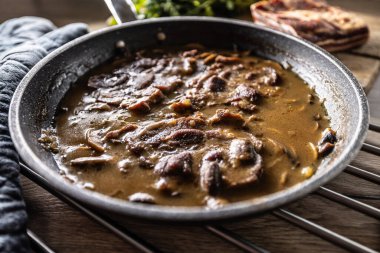 Mantar soslu kızarmış domuz boynu ve seramik Pan sosu..