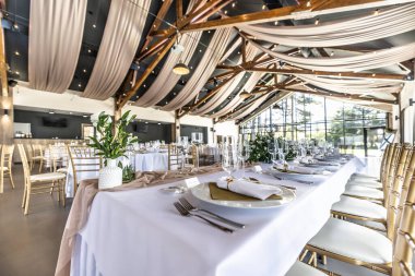 Düğün hazırlığı ve dekore edilmiş masalar modern bir ahşap tavanlı performans salonunun güzel bir iç mekanı..