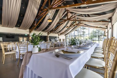 Düğün hazırlığı ve dekore edilmiş masalar modern bir ahşap tavanlı performans salonunun güzel bir iç mekanı..