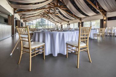 Düğün hazırlığı ve dekore edilmiş masalar modern bir ahşap tavanlı performans salonunun güzel bir iç mekanı..