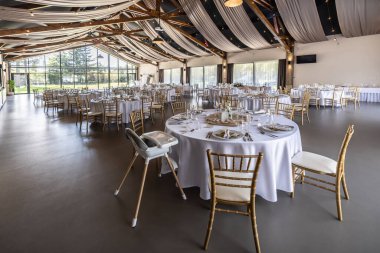 Düğün hazırlığı ve dekore edilmiş masalar modern bir ahşap tavanlı performans salonunun güzel bir iç mekanı..