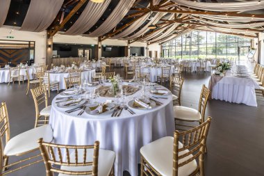 Düğün hazırlığı ve dekore edilmiş masalar modern bir ahşap tavanlı performans salonunun güzel bir iç mekanı..