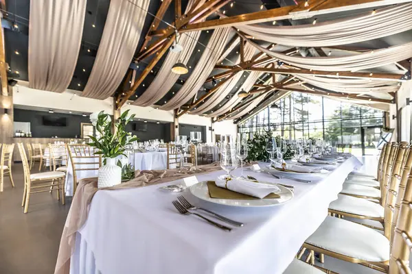 Düğün hazırlığı ve dekore edilmiş masalar modern bir ahşap tavanlı performans salonunun güzel bir iç mekanı..