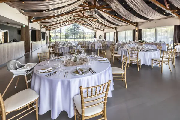 Düğün hazırlığı ve dekore edilmiş masalar modern bir ahşap tavanlı performans salonunun güzel bir iç mekanı..