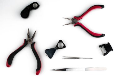 Beyaz arka planda mücevher aletleri. Kuyumcunun işi için bir takım aletler. Seçici odak.  