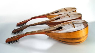 Beyaz arka planda izole edilmiş üç eski mandolin. Seçici odak.