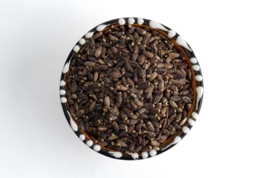 Seramik kasede bir avuç tohum. Beyaz arka planda izole edilmiş. Seçici odak