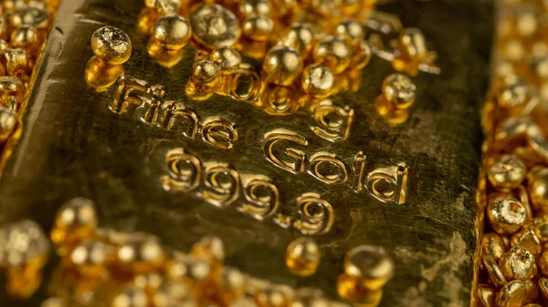 Gold bar in a pile of gold granules. Selective focus.