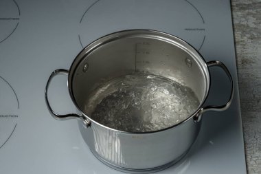 Paslanmaz bir tencerede su kaynatmak. Seçici odak.