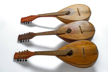 Beyaz arka planda izole edilmiş üç eski mandolin. Yan görüş. Seçici odak.