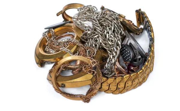 Bir altın parçası. Eski ve kırık mücevherler, sikkeler, gümüş ve altından saatler ve beyaz bir arka planda altın kaplama.