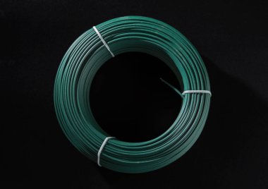 Yeşil PVC kaplamalı bir bobin. Siyah bir arkaplanda izole edilmiş.