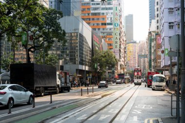Hong Kong, 25 Mart 2019: Bulutlu bir günde Hong Kong sokaklarında gökdelenler arasında gezinmek