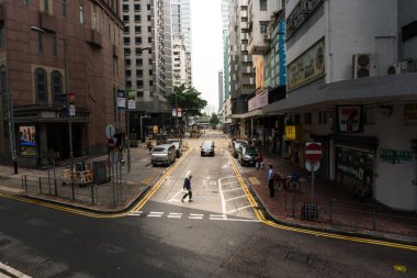 Hong Kong, 25 Mart 2019: Bulutlu bir günde Hong Kong sokaklarında gökdelenler arasında gezinmek