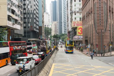 Hong Kong, 25 Mart 2019: Bulutlu bir günde Hong Kong sokaklarında gökdelenler arasında gezinmek