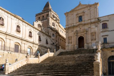 Noto,Italy-May 8, 2022:people stroll in Noto in front off the Church of San Francesco d'Assisi all'Immacolata during a sunny day