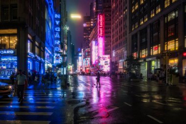 New York City, ABD - 9 Ağustos 2019: İnsanlar ve turistler Manhattan 'da bir yaz gecesi boyunca Time Square' in ışıkları ve gökdelenleri arasında gezinirler