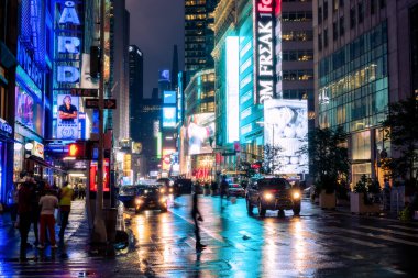 New York City, ABD - 9 Ağustos 2019: İnsanlar ve turistler Manhattan 'da bir yaz gecesi boyunca Time Square' in ışıkları ve gökdelenleri arasında gezinirler