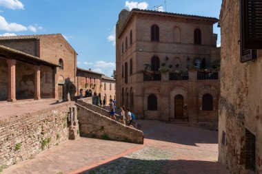 Certaldo, İtalya-Ağustos 9, 2020: İnsanlar ve turistler güneşli bir günde Toskana 'nın Certaldo antik köyünde dolaşıyorlar.