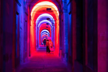Bologna, Italy- 23 Haziran 2023: İnsanlar Bologna Atari Festivali 'nin ilk baskısı için aydınlatılmış San Luca tapınağına giden atari salonlarının altında gece gezintisine çıkıyorlar. Burası dünyanın en uzun atari salonu ve artık Unesco mirasının bir parçası.