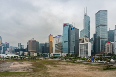 Hong Kong, 25 Mart 2019: Bulutlu bir günde dönme dolabın yanındaki Hong Kong gökdelenlerinin görüntüsü