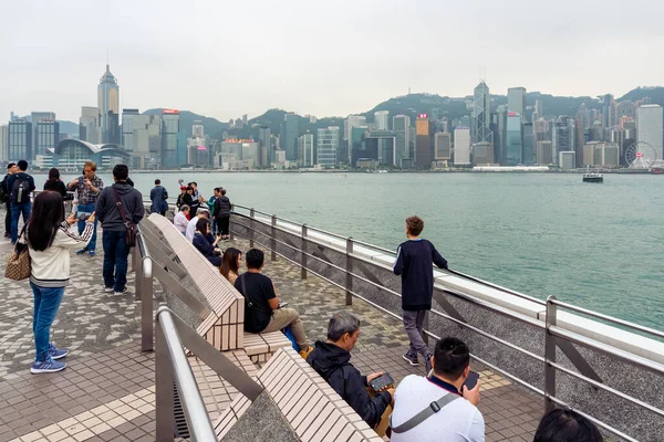 stock image Hong Kong,March 25,2019:People strolling on the Avenue of star on the Victoria Harbour during a cloudy day