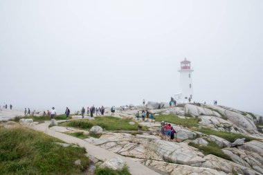 Peggy 'nin Koyu, Kanada - 13 Ağustos 2015: Sisli bir günde Nova Scotia-Kanada' daki Peggy 'nin Koyu deniz fenerinin yakınındaki insanlar