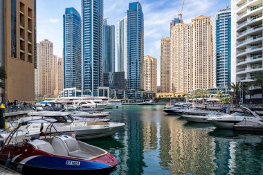 Dubai, Birleşik Arap Emirlikleri - 12 Mart 2023: Güneşli bir günde Dubai Marina 'da yürürken Dubai gökdelenlerinin manzarası