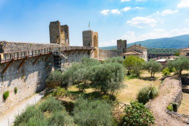 Monteriggioni, İtalya-Ağustos 10, 2020: Güneşli bir günde duvarların üzerinden ortaçağ köyü manzarası