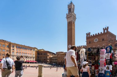 Siena, İtalya-Ağustos 10, 2020: Güneşli bir günde Siena 'da Campo Meydanı yakınlarında turistler ve hediyelik eşya dükkanları