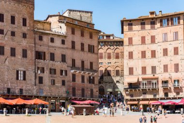 Siena, İtalya-Ağustos 10, 2020: İnsanlar ve turistler güneşli bir günde ünlü Piazza del Campo 'yu ziyaret ediyorlar