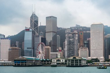 Hong Kong, 27 Mart 2019: Bulutlu bir günde vapurla Victoria Limanı 'ndan geçen Hong Kong gökdelenlerinin görüntüsü