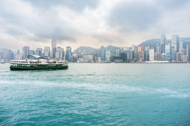 Hong Kong, 27 Mart 2019: Bulutlu bir günde vapurla Victoria Limanı 'ndan geçen Hong Kong gökdelenlerinin görüntüsü