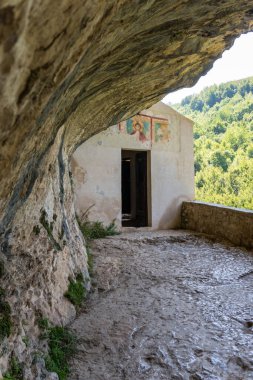 L 'Aquila, İtalya-Ağustos 12, 2021: Eski bir kilise San Bartolomeo' da iyi korunmuş bir fresk, sunak ve münzevi hücreleri ile bir uçuruma gömüldü..
