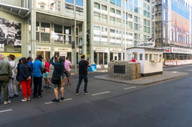Berlin, Almanya-Ağustos 10, 2022: Turistler bulutlu bir günde Berlin 'deki ünlü Charlie Kontrol Noktasında fotoğraf kuyruğu oluşturuyorlar