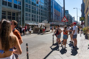 Berlin, Almanya-Ağustos 10, 2022: Turistler bulutlu bir günde Berlin 'deki ünlü Charlie Kontrol Noktasında fotoğraf kuyruğu oluşturuyorlar