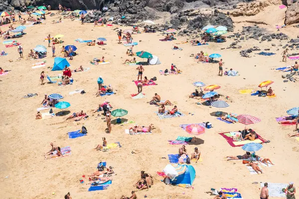 Lanzarote, İspanya - 15 Ağustos 2018: İnsanlar bir yaz günü Lanzarote 'un birçok plajından birinde dinleniyor.