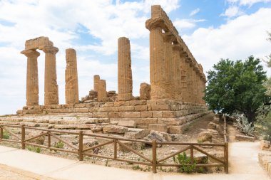 Agrigento, İtalya-10 Mayıs 2022: güneşli bir günde Agrigento yakınlarındaki Valle di Templi arkeoloji parkının içindeki heybetli Yunan Juno Tapınağı